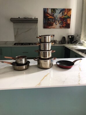 A kitchen with a marble countertop, a stack of pots, a frying pan, and a coffee maker. - Prime Elgon View 5BR Family Home Private Secure in Eldoret (Eldoret)