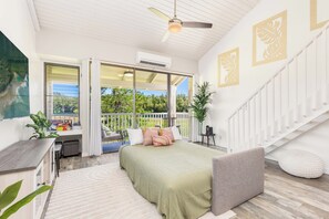 Une chambre à coucher avec un lit, un bureau et un balcon.