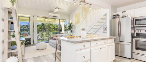 A modern kitchen with white cabinetry, stainless steel appliances, and a central island.
