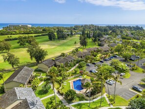Um resort com piscina, vários edifícios e um campo de golfe.