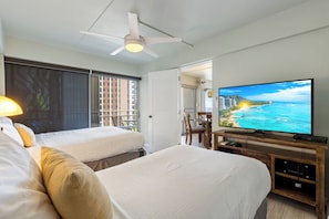 Ein Hotelzimmer mit zwei Betten, einem Fernseher und Meerblick.