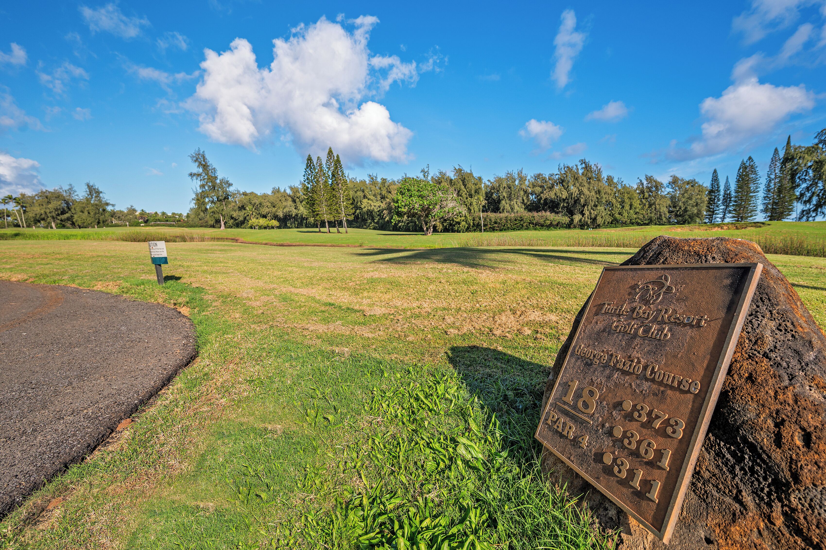 A golf course with a sign indicating hole number 18, par 4, and a score of 311.