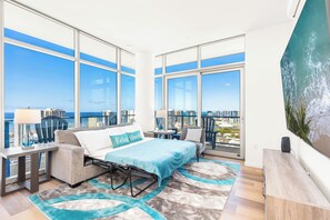 A modern bedroom with a bed, a desk, a chair, and a large window offering a city view. - Breathtaking Ocean View Penthouse in the Heart of Honolulu (Honolulu)