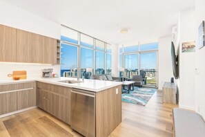 A modern kitchen with a central island, large windows, and a city view. - Breathtaking Ocean View Penthouse in the Heart of Honolulu (Honolulu)