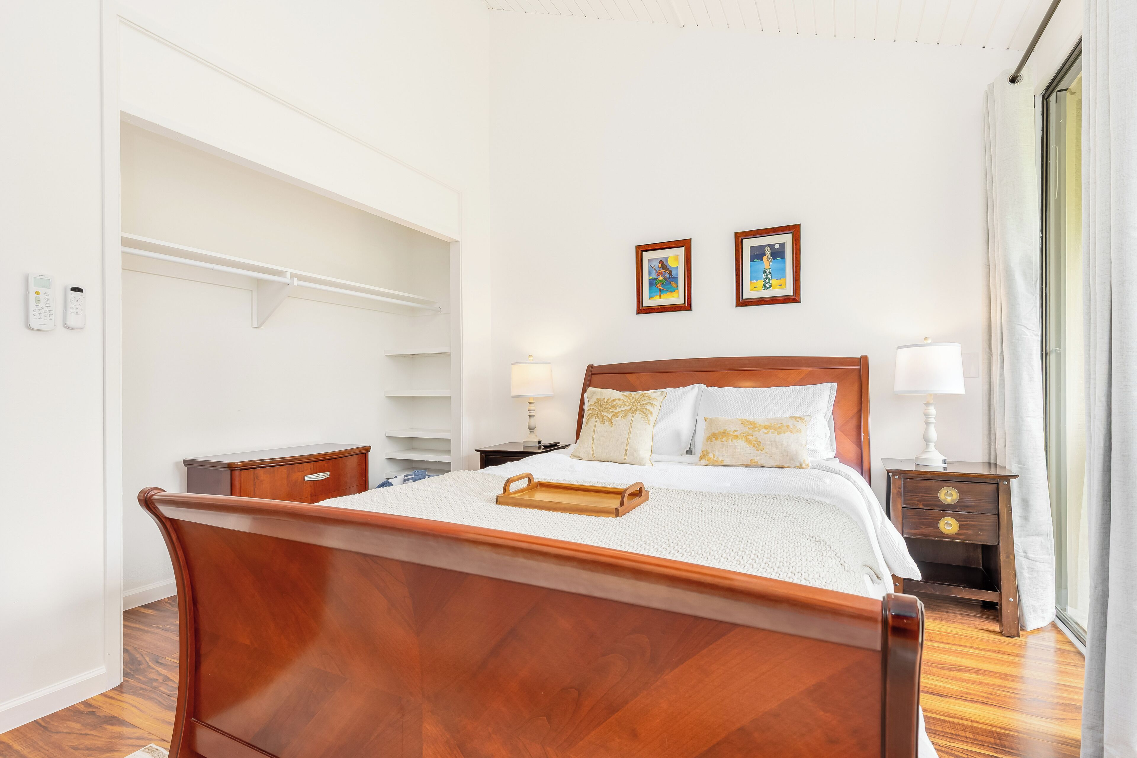 A neatly arranged bedroom with a wooden bed, bedside tables, a nightstand, and a wardrobe.