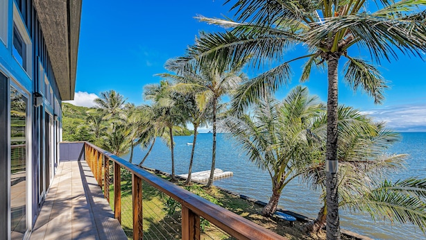 Un balcone con vista sull'oceano e palme.