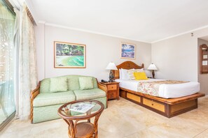 A hotel room with a bed, a sofa, a small table, and two wall-mounted paintings. - City & Mountain Views Condo at Luana Waikiki Hotel Short Walk to the Beach (Honolulu)