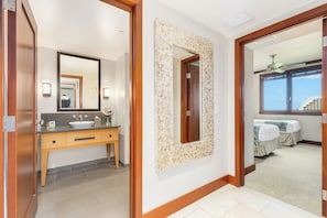 A hotel room with a wooden door, a large mirror, a sink, and a window with a view. - Beach Villas Oceanfront Resort at Ko Olina W/unobstructed Views (Kapolei)