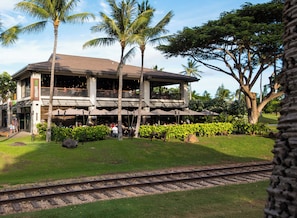 A two-story building with a balcony, surrounded by greenery and palm trees. - Beach Villas Oceanfront Resort at Ko Olina W/unobstructed Views (Kapolei)