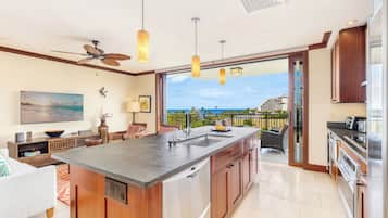 A modern kitchen with a large island, built-in appliances, and a view to the outdoors.