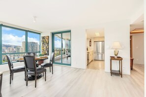 Eine moderne Wohnung mit Essbereich, Küche und großen Fenstern mit Blick auf die Stadt.