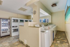 A laundry area with multiple washing machines and a vending machine. - Diamond Head & Golf Course Views at Island Colony W/amazing Amenities (Honolulu)