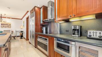 A modern kitchen with wooden cabinets, stainless steel appliances, and a built-in oven.