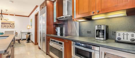 Una cocina moderna con armarios de madera, electrodomésticos de acero inoxidable y un horno empotrado.
