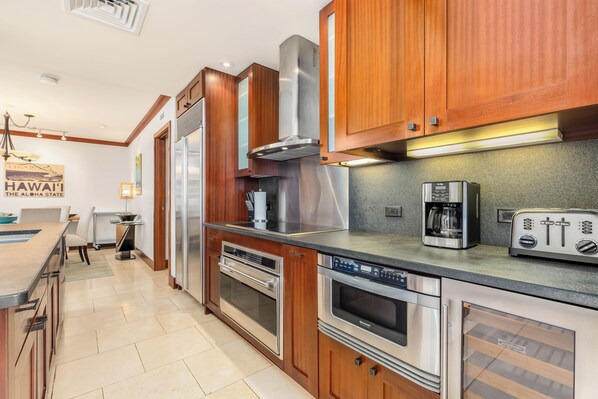 A modern kitchen with wooden cabinets, stainless steel appliances, and a built-in oven.