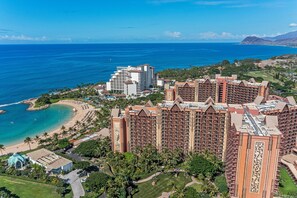 A resort with multiple high-rise buildings, a beach, and a golf course.