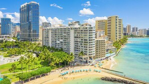 A beachfront hotel with multiple high-rise buildings, a sandy beach, and clear blue waters. - Beachfront Property W/sand Access at Waikiki Shore Condo With Full Kitchen (Honolulu)