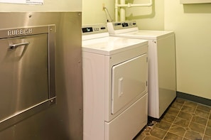 A laundry room with a stainless steel appliance labeled 'RUBBISH' and a white washing machine. - Ocean-city Views at Marine Surf Close to the Beach W/parking & Full Kitchen (Honolulu)
