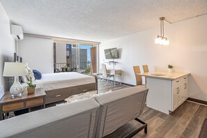 A modern hotel room with a bed, desk, and seating area. - Ocean-city Views at Marine Surf Close to the Beach W/parking & Full Kitchen (Honolulu)