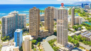 A high-rise hotel with multiple floors, surrounded by lush greenery and a view of the ocean. - Unique 2 Story Loft Condo at The Windsor W/parking and Rooftop Sky Terrace (Honolulu)