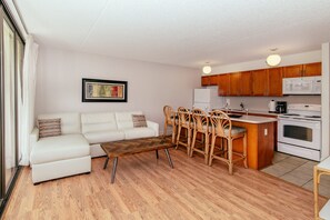 A modern kitchen with wooden cabinets, a white refrigerator, and a microwave. - Ocean-city Views Family Getaway at Waikiki Banyan Half a Block to the Beach (Honolulu)