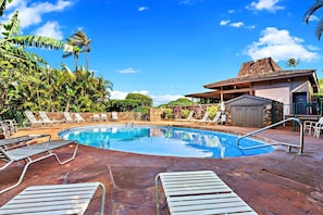 A swimming pool with lounge chairs and a covered area, surrounded by tropical vegetation. - Maui Kaʻanapali Condo - Ocean View, Walk to Beach (Lahaina)