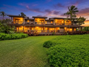 A two-story building with multiple balconies and a well-maintained lawn. - Maui Kaʻanapali Condo - Ocean View, Walk to Beach (Lahaina)