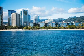 A coastal cityscape with modern high-rise buildings and a beach. - City-mt Views Family Escape at the Waikiki Sunset Near Shops & Restaurants (Honolulu)