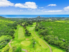 Eine Vogelperspektive auf einen Golfplatz mit mehreren Spielbahnen, Grüns und Bäumen.