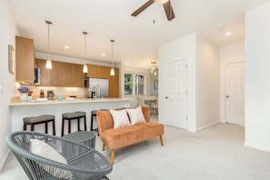 A modern kitchen with wooden cabinets, a stainless steel refrigerator, and pendant lights. - Tranquil Vacation Home in Makaha Valley Near Beach W/exterior Dining & Bbq (Waianae)