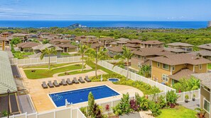 Zona residencial con piscina, casas y vista al océano.