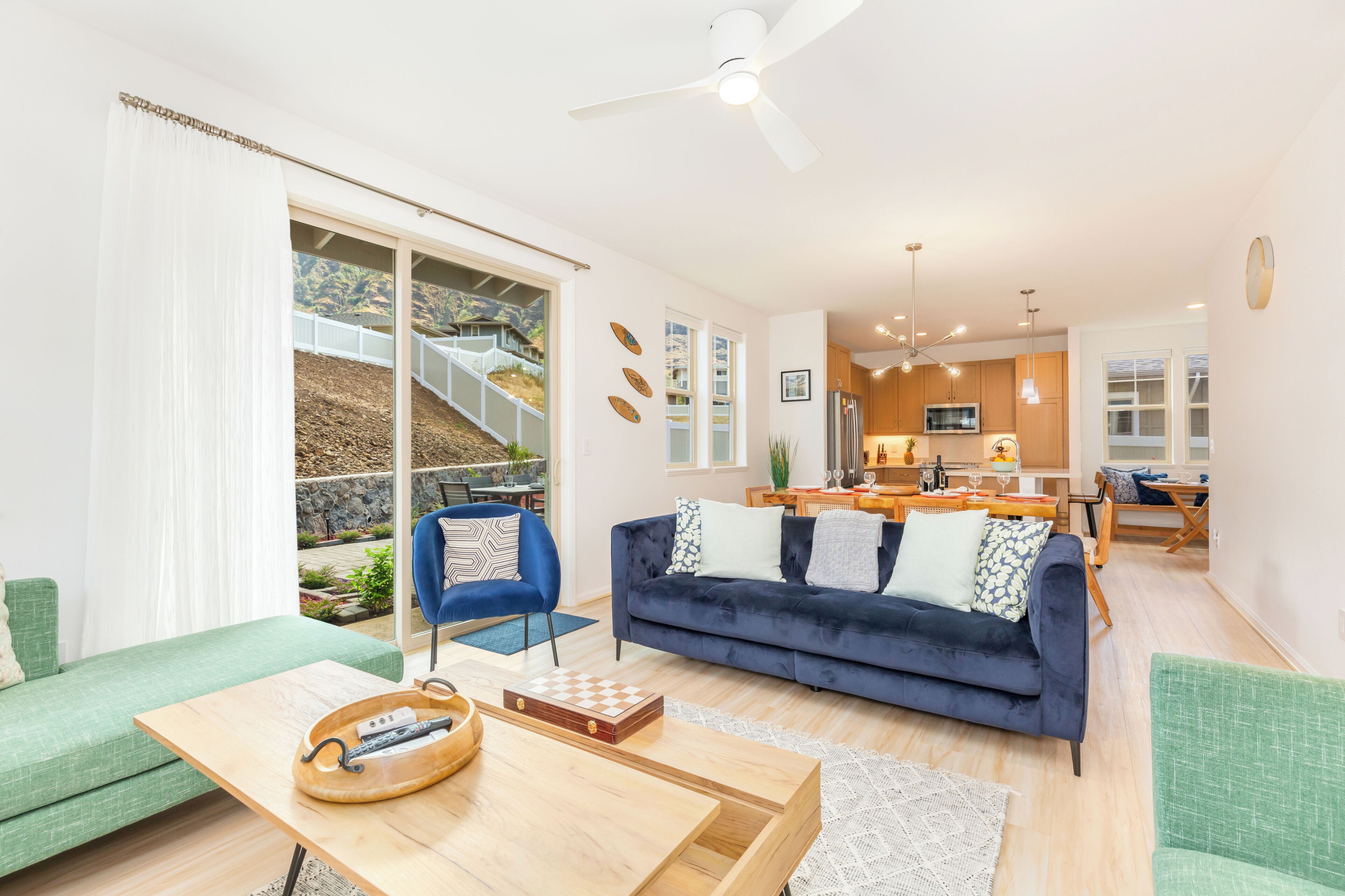 A modern living room with a sofa, a coffee table, and a dining area with a table and chairs.