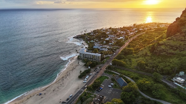 An aerial view of a coastal town with a beach, a road, and a building with multiple floors. - Family Vacation Home W/ocean View at Makaha Valley in Secure Gated Community (Waianae)
