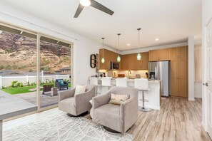 Eine moderne Küche mit Kühlschrank, Mikrowelle und einer Bar mit Sitzgelegenheit.