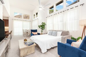 Ein modernes Wohnzimmer mit einem Bett, einer Sitzecke und einem Esstisch.