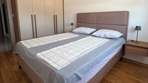 Una camera da letto con un letto, un armadio, un comodino e una lampada.