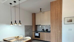 Una cucina moderna con mobili in legno, forno a incasso e lampade a sospensione.