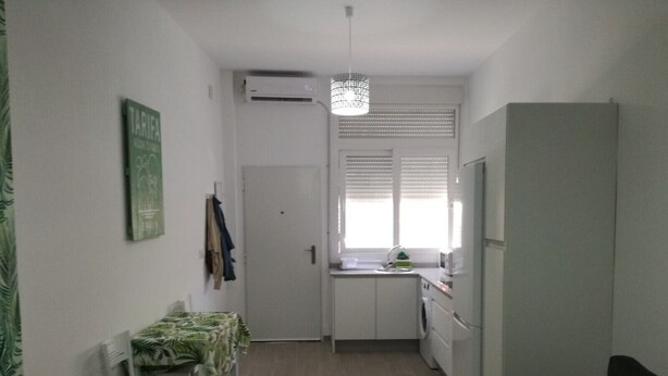 A compact living space with a kitchenette, a dining area, and a seating area. - Apartment 'Apartmento La Palmera' with Wi-Fi and Air Conditioning (Tarifa)