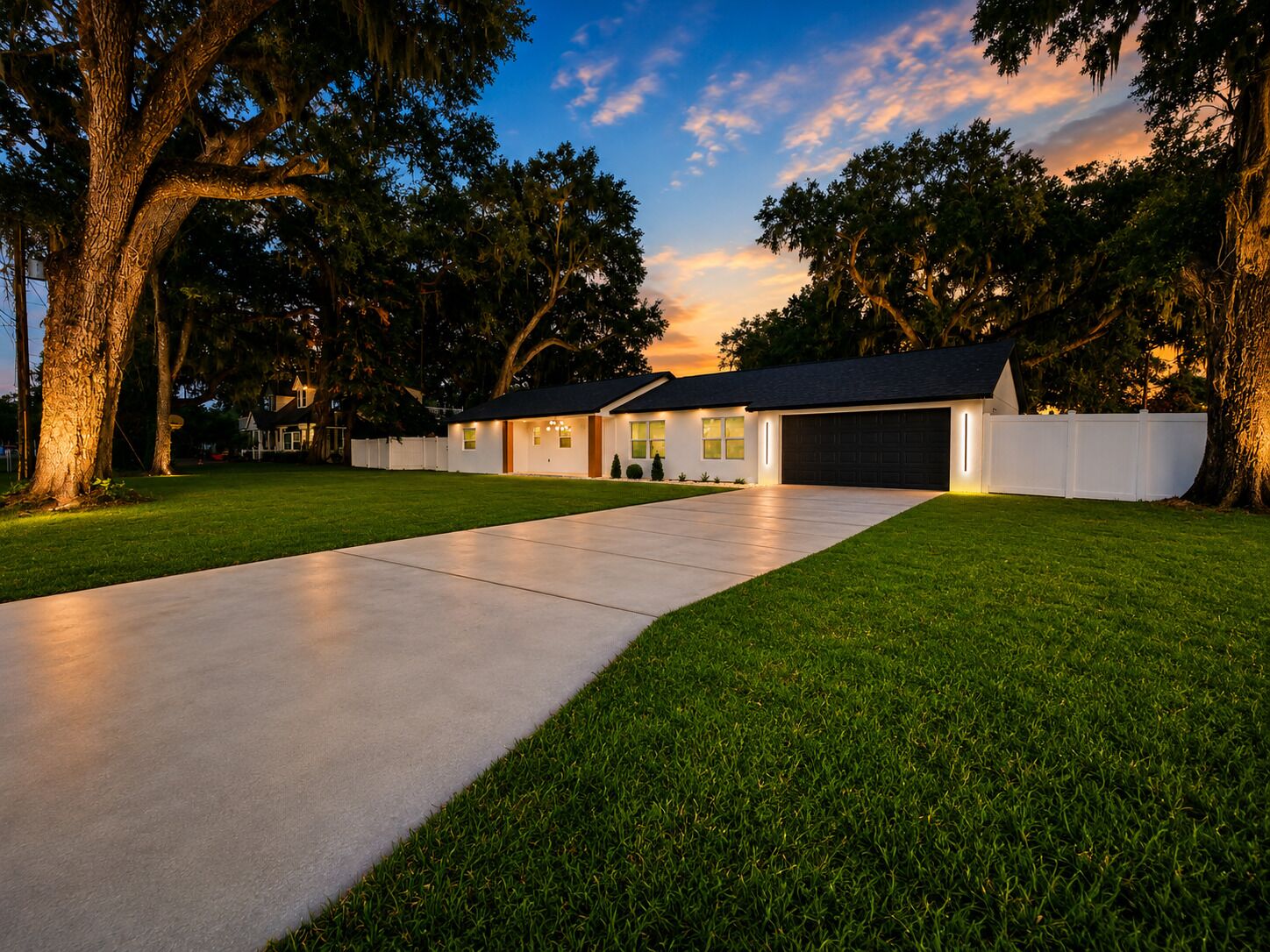 A modern two-story house with a wide driveway and a well-maintained lawn.