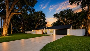A modern two-story house with a wide driveway and a well-maintained lawn. - Elegant 4BR Retreat Near Tampa with Private Office (Brandon)