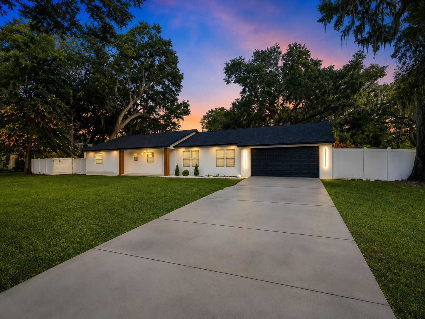 A modern single-story house with a concrete driveway leading to a garage.
