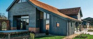 Una moderna casa a due piani con ampie finestre, fondamenta in mattoni e tetto spiovente.