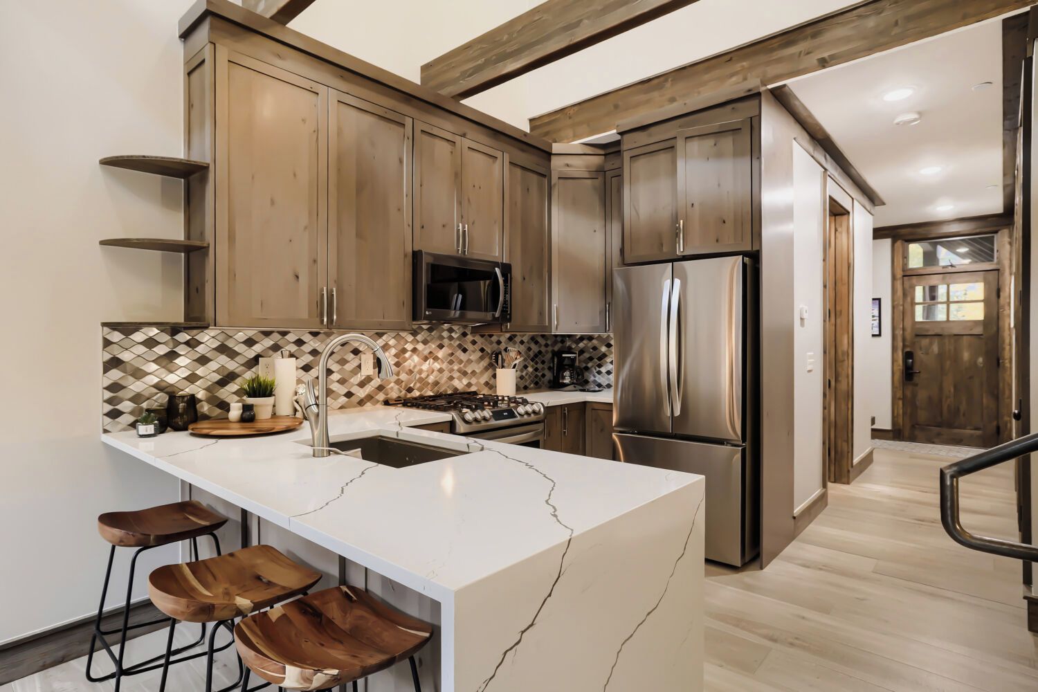Una cocina moderna con una isla grande, electrodomésticos de acero inoxidable y muebles de madera.