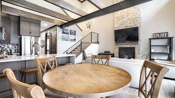 Een moderne keuken met een centraal eiland, houten stoelen en een ronde tafel.