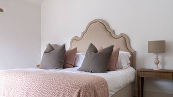 A neatly made bed with a patterned blanket and several pillows.
