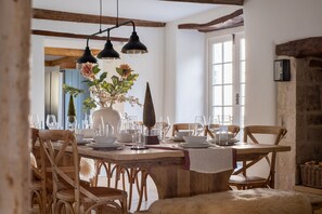 A dining area with a wooden table, chairs, and hanging pendant lights.