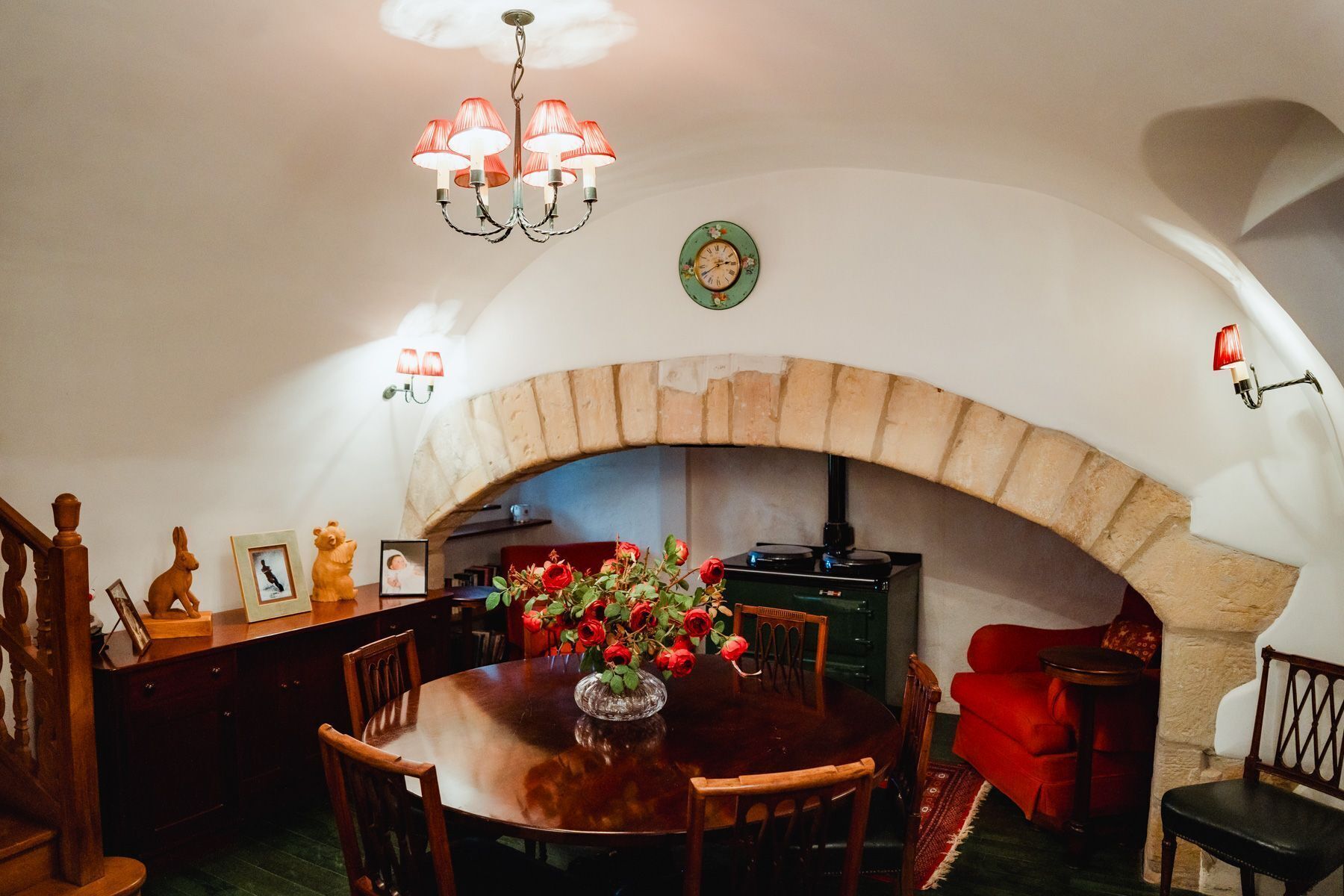 Comedor con chimenea de piedra, muebles de madera y una lámpara de araña.