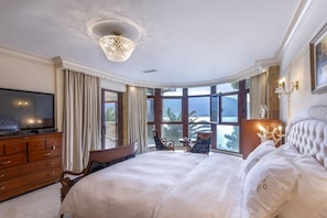 A spacious bedroom with a large bed, a television, a chandelier, and a view of the outdoors. - Villa Verity - Nine Bedroom Villa, Sleeps 21 (Porto Germeno)