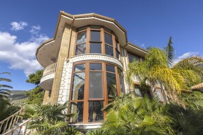 A corner building with a stone facade, large windows, and a balcony. - Villa Verity - Nine Bedroom Villa, Sleeps 21 (Porto Germeno)