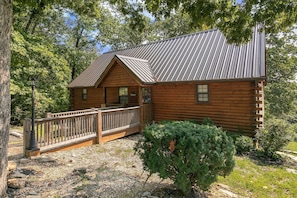 A log cabin with a metal roof, a wooden deck, and a small garden area. - Deluxe Notch Estates Cabin, Close to SDC - 4 BR Suites, 2 Living Areas - 35 (Branson West)